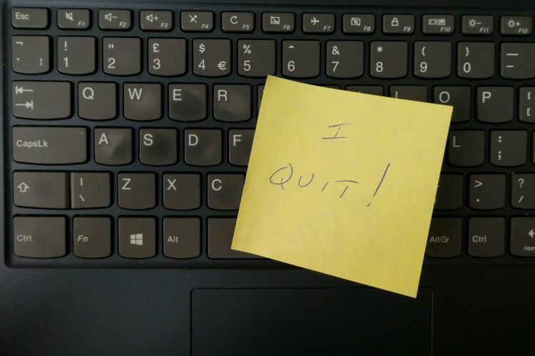 Closeup of a keyboard covered with a post-it note reading "I quit!"