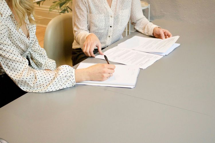a woman signing a document