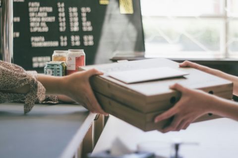 person handing over a stack of papers to another person