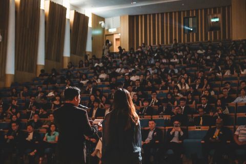 two people giving a presentation on a stage in front of an audience