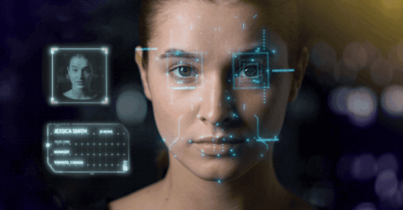 Woman looking at you and a computer screen