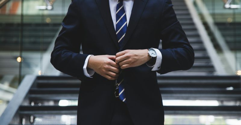 a man buttoning his suit jacket