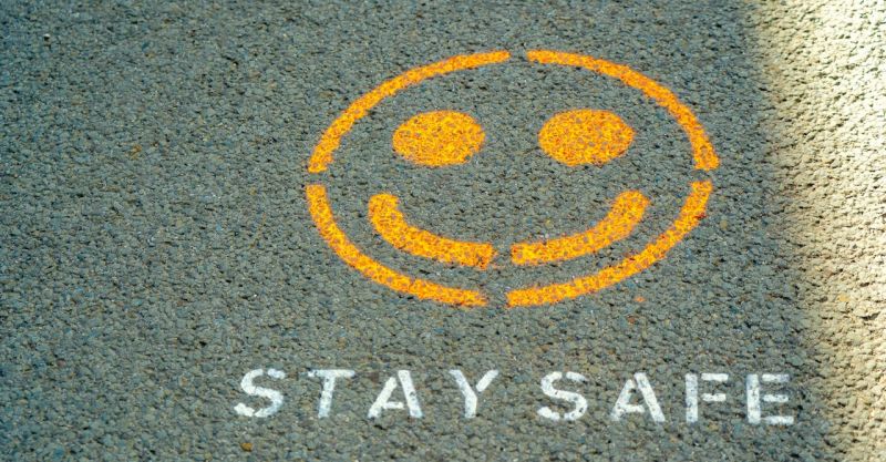 The words "Stay Safe" and a smiley face painted on the ground.