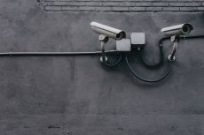 Two surveillance cameras attached to a wall