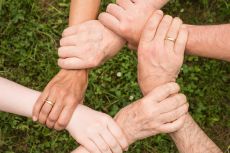People with hands holding arms in a circle.